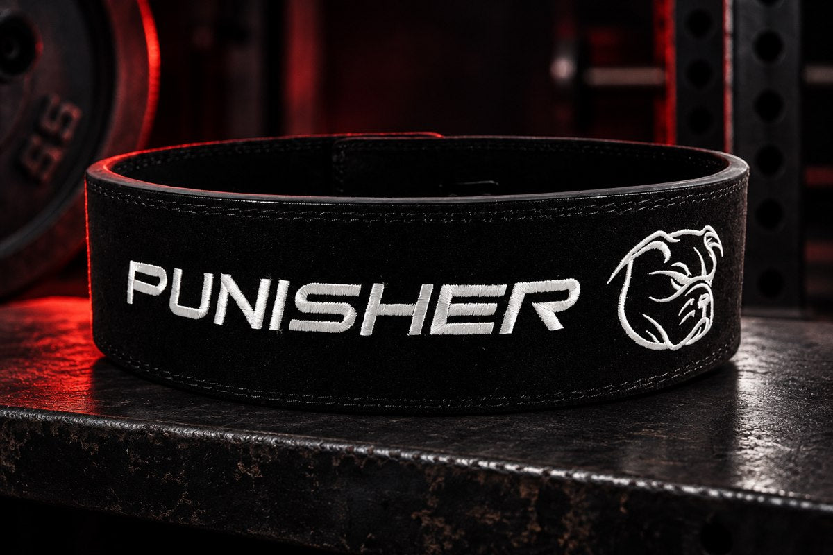 Black Punisher 10mm lever belt in a dark gym with red side lighting